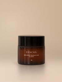 REPLENISH Moisture-Lock Lip Balm in an amber glass jar on a warm studio backdrop